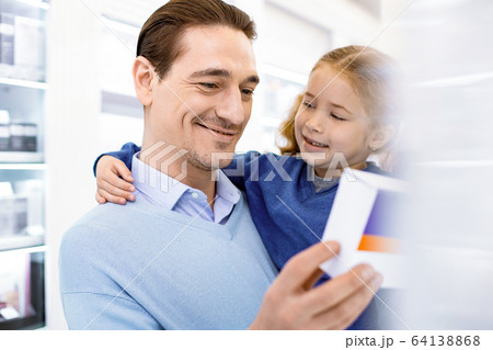 Smiling dad with daughter choosing a medical drug. 64138868