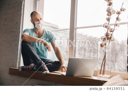 Young man doing yoga at home while being quarantine and freelance working 64139551