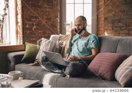Young man doing yoga at home while being quarantine and freelance working 64139666
