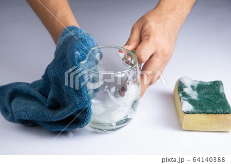 washing clear glass by bare hand and blue rag sponge foam on white background stock photo 64140388