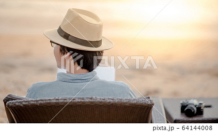 Asian man sitting on beach chair looking at the 64144008