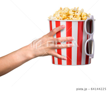 Woman hand holding striped bucket with popcorn and 3D glasses isolated on white 64144225