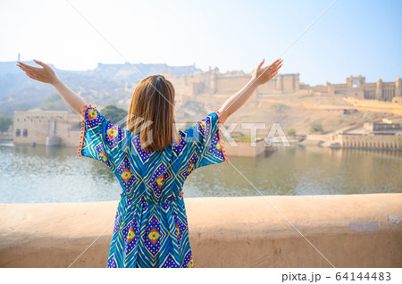 Young woman in colorful dress enjoy the view of Amber palace in Jaipur Young woman in colorful dress enjoy the view of Amber palace in Jaipur 64144483