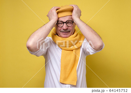 senior man in funny beret and scarf having headache senior man in funny beret and scarf having headache 64145752