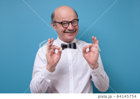 Caucasian man in white shirt smiling on camera with alright ok sign Caucasian man in white shirt smiling on camera with alright ok sign 64145754