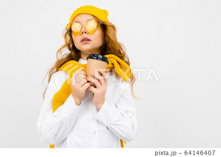 girl in winter hat and scarf with a glass of hot drink in her hands on a white background with copy girl in winter hat and scarf with a glass of hot drink in her hands on a white background with copy 64146407