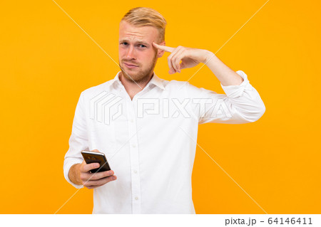guy in a white t-shirt with a cell phone in his hand guy in a white t-shirt with a cell phone in his hand 64146411