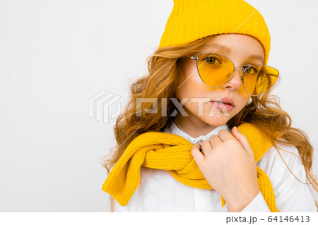 romantic teenager girl with yellow retro glasses and with a yellow hat and scarf on an isolated 64146413