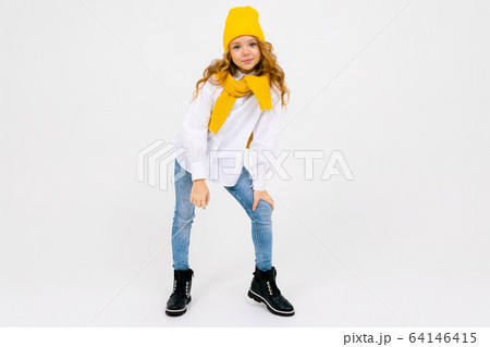 teenager model girl in a white shirt and jeans romantically stands on a white isolated background 64146415