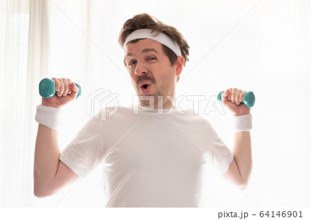 Funny mature man exercising at home holding weights 64146901