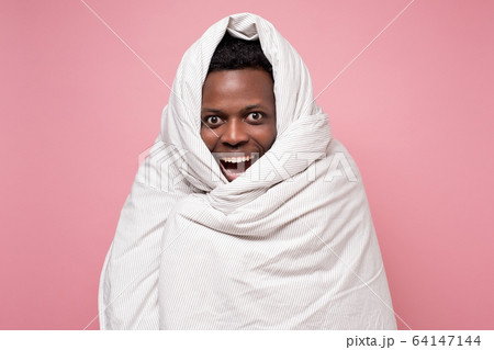Funny handsome african man in white blanket resting. 64147144