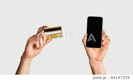 Online shopping. Unrecognizable man holdng credit card and smartphone with empty screen, space for design 64147359