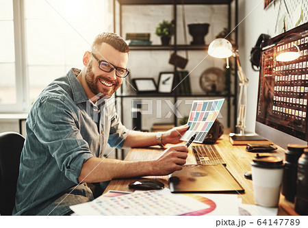 Young man working at computer at workplace. 64147789