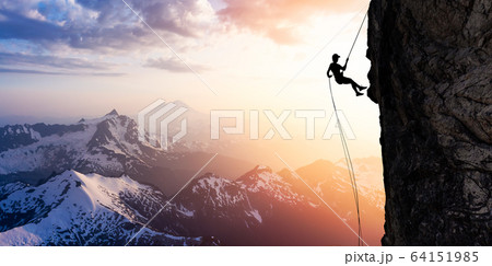 Silhouette Rappelling from Cliff 64151985