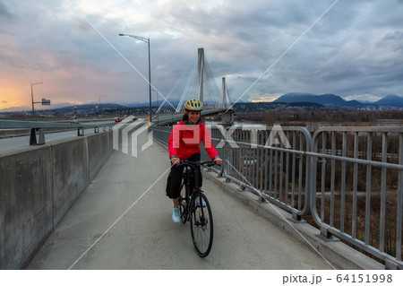 Caucasian Woman riding a Bicycle on a path at Port Mann Bridge 64151998