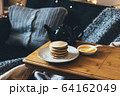 Pancakes with honey on wooden tray in cozy room. 64162049