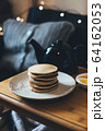 Pancakes with honey on wooden tray in cozy room. 64162053