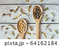 Herbal pills and dry herbs on wooden background. 64162184