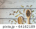 Herbal pills and dry herbs on wooden background. 64162189