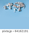 White medical pills on blue background.  64162191