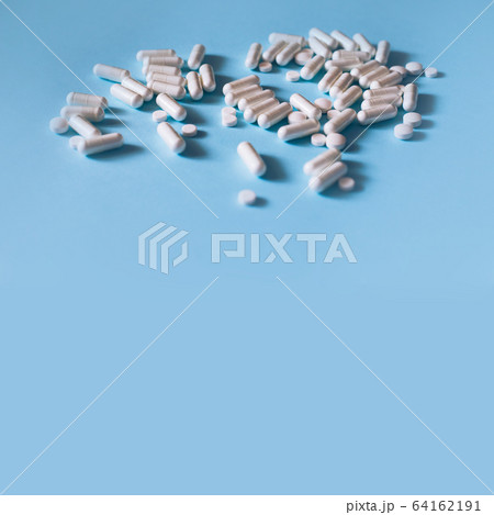 White medical pills on blue background. White medical pills on blue background. 64162191