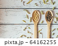 Herbal pills and dry herbs on wooden background. 64162255