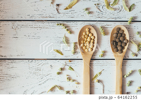 Herbal pills and dry herbs on wooden background. Herbal pills and dry herbs on wooden background. 64162255