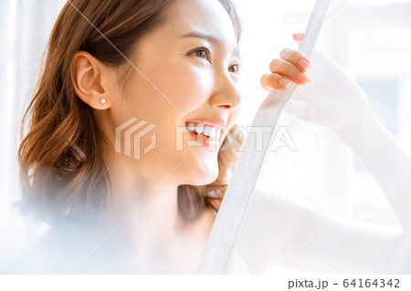 美人　女性　明るい　部屋　室内　カーテン　笑顔　人物　素材 64164342