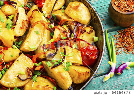 Roasted potato in a frying pan 64164378