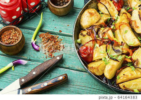 Roasted potato in a frying pan 64164383