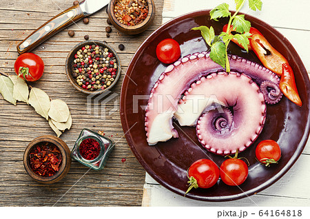 Raw octopus on wooden table Raw octopus on wooden table 64164818