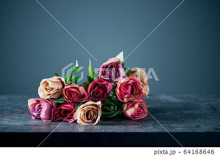 Artificial antique roses on stony background. 64168646