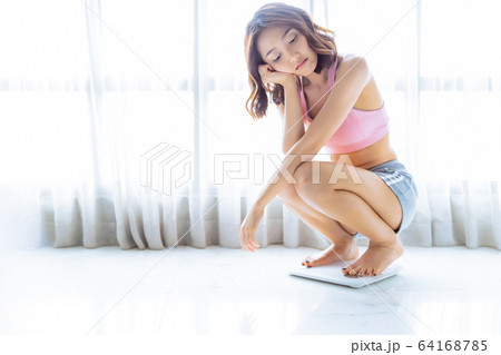 可愛い　女性　ダイエット　体重計　測る　部屋　人物　素材 64168785