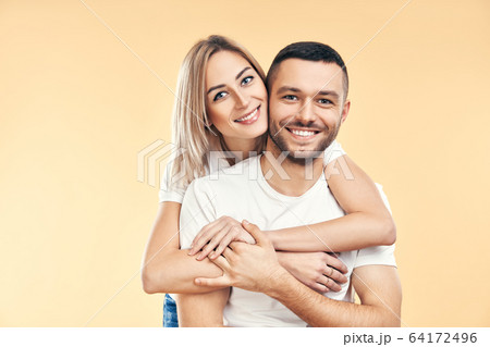 Happy smiling couple in love on beige background 64172496