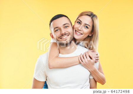 Happy smiling couple in love on yellow background Happy smiling couple in love on yellow background 64172498