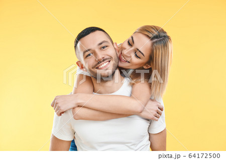 Happy smiling couple in love on yellow background 64172500
