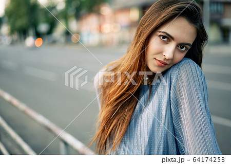 Close up young beautiful woman portrait posing in the city street 64174253