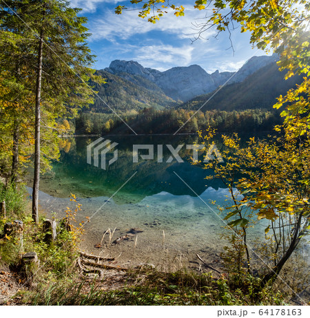 Peaceful autumn Alps mountain lake with clear 64178163