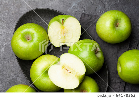 Ripe green apple fruits on dark stone table Ripe green apple fruits on dark stone table 64178362