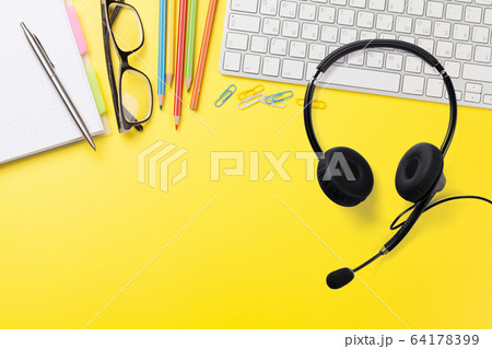 Office yellow backdrop with supplies and headset Office yellow backdrop with supplies and headset 64178399