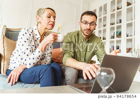 Man in eyeglasses pointing at his computer 64178654