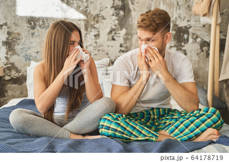 Attentive bearded male person wiping his nose Attentive bearded male person wiping his nose 64178719