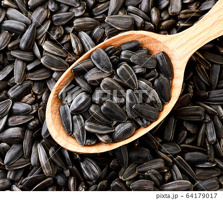 Sunflower seeds in a wooden spoon, background. The 64179017