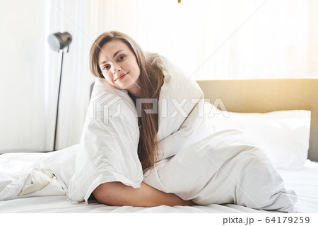 Tranquil pleased girl looking at the camera Tranquil pleased girl looking at the camera 64179259
