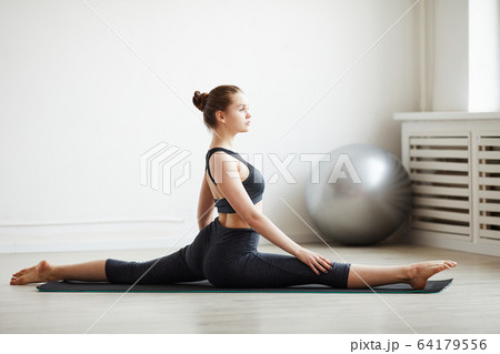 Woman sitting on the splits Woman sitting on the splits 64179556