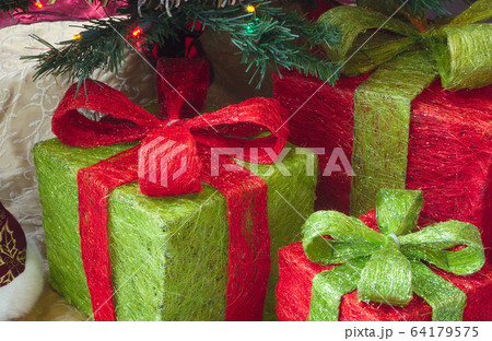 christmas gifts under tree with lights, fir and decorations christmas gifts under tree with lights, fir and decorations 64179575
