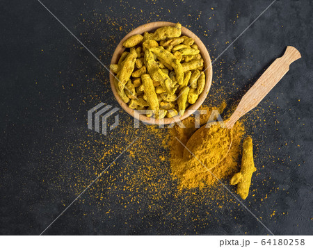 Turmeric powder and roots turmeric on black  64180258