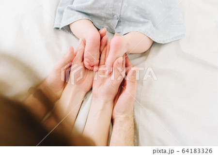 Parents holding feet of their baby Parents holding feet of their baby 64183326
