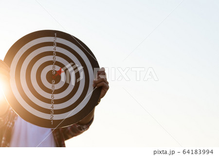 Man hand holding a target with darts hitting the 64183994