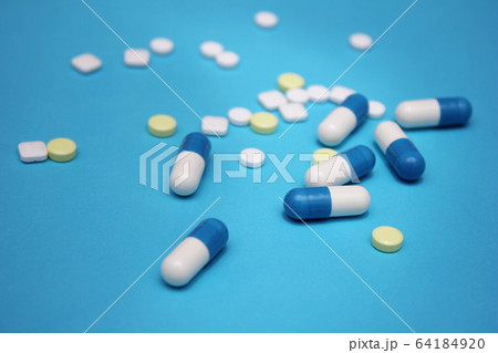 a lot of pills and pills on it on a blue 64184920